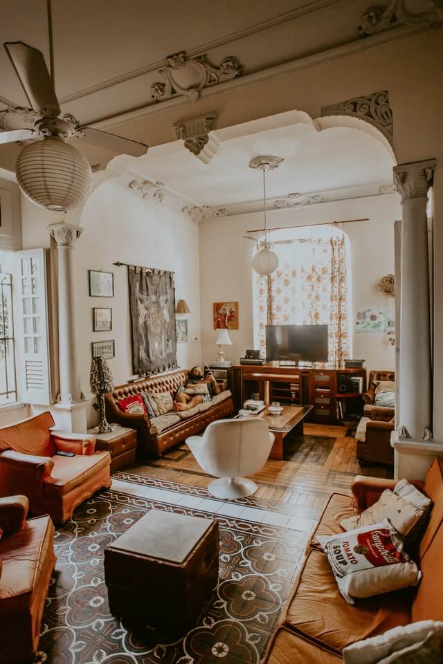 big room with decorative column full-vh background-img-card-02-01s and decorative elements on the ceiling, mixture of modern and old style furnishings, sofas and chairs